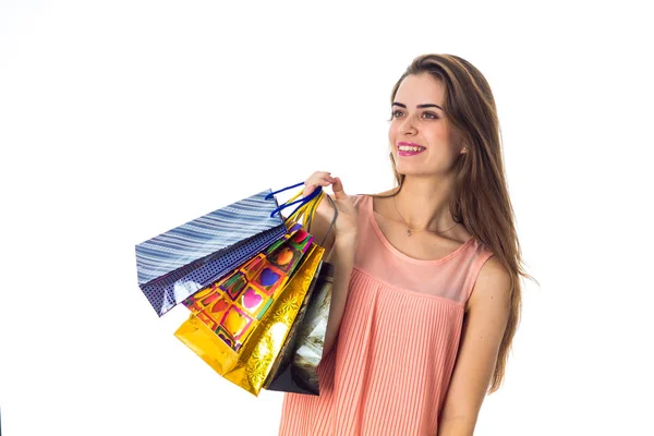 Doce menina mantém pacotes com compras na mão isolado no fundo branco — Fotografia de Stock