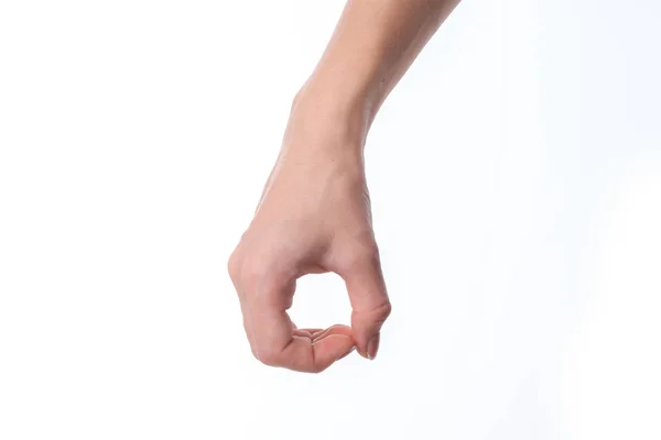 Main féminine abaissée et montrant le geste avec les doigts serrés en termes d'isolement sur fond blanc — Photo