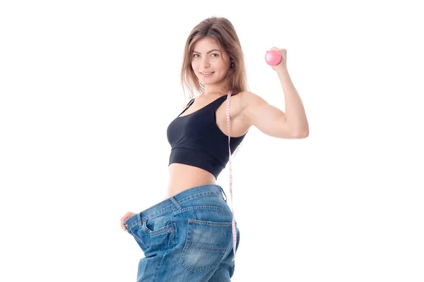 Slim young girl standing in the wide trousers and shows muscle on hand isolated  white background — Stock Photo, Image