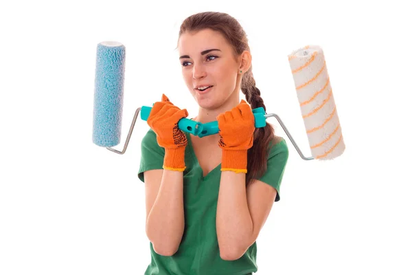 Śmieszne Młoda Dziewczyna Brunetka konstruktora w mundurze sprawia, że remont z farby rolki w jej ręce na białym tle — Zdjęcie stockowe