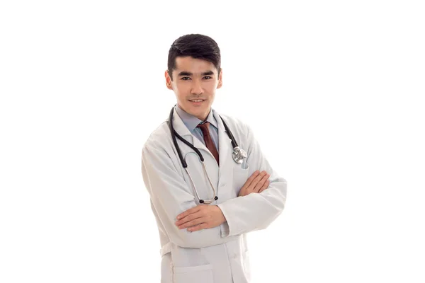 청진 기 교차 손으로 카메라 흰색 배경에 고립에 미소와 유니폼에 잘생긴 우아한 의사 — 스톡 사진