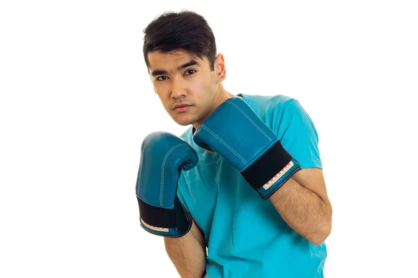 Esmer yakışıklı sporcu mavi boks eldivenleri ve beyaz arka plan üzerinde izole boks pratik üniforma — Stok fotoğraf