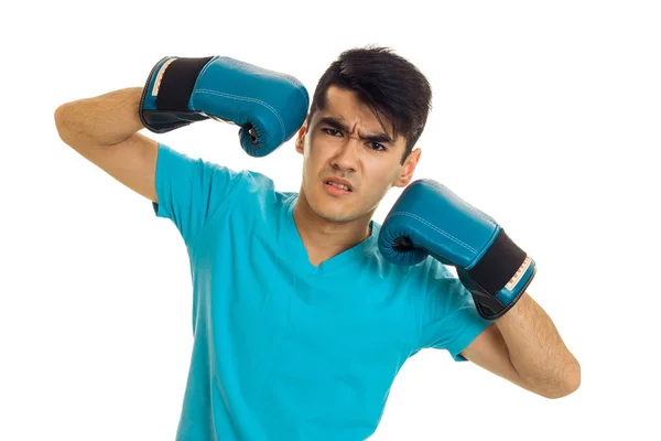 Irritado morena desportista em luvas de boxe azul e uniforme praticando boxe isolado no fundo branco — Fotografia de Stock