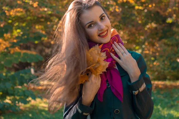Hermosa chica de pie sonriendo en el parque y su pelo en el viento — Foto de Stock