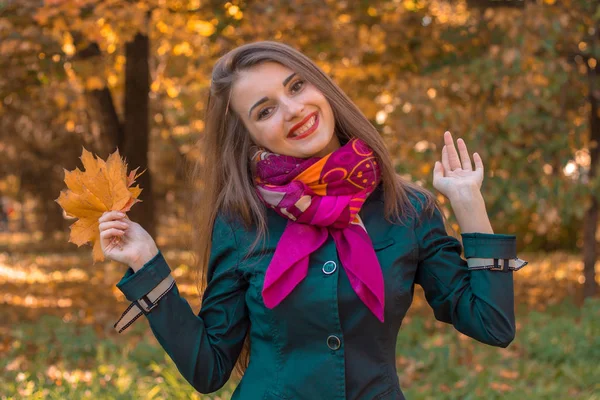 Junges fröhliches Mädchen steht im Herbst auf der Straße und hebt die Hände — Stockfoto