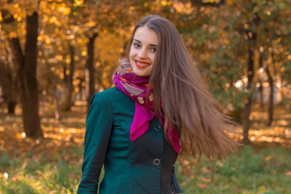 Chica con el pelo largo liso se para en otoño Parque y sonríe — Foto de Stock