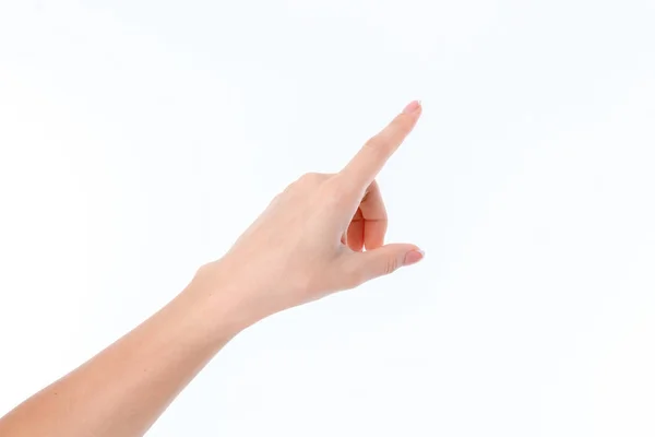 Mano femenina extendida hacia un lado y apuntando con el dedo aislado sobre fondo blanco — Foto de Stock