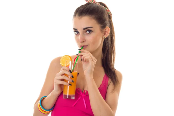 Jolie jeune femme aux cheveux foncés en chemise d'été rose boire cocktail orange et sourire isolé sur fond blanc — Photo