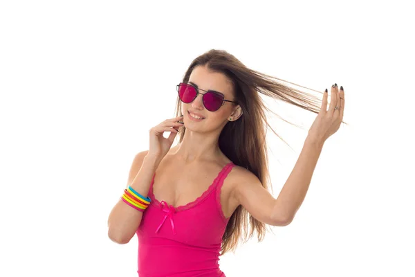 Chica linda joven con el pelo oscuro en camisa de verano rosa y gafas de sol sonriendo aislado sobre fondo blanco — Foto de Stock