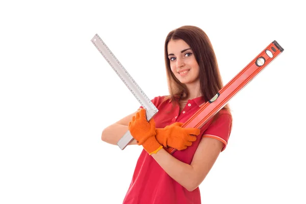 Bastante joven chica constructora delgada hace renovaciones con herramientas en sus manos aisladas sobre fondo blanco — Foto de Stock