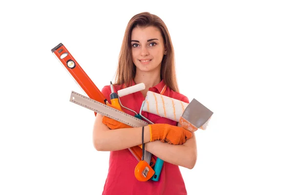 Привлекательный молодой стройный строитель девушка делает ремонт с инструментами в руках изолированы на белом фоне — стоковое фото