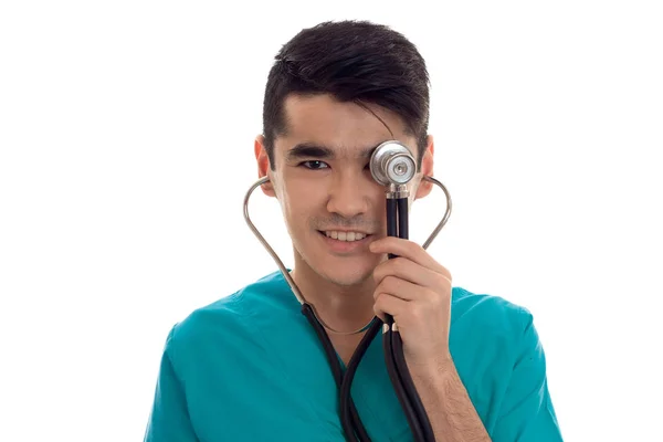 Jovem morena feliz médico homem em uniforme azul com estetoscópio sorrindo isolado no fundo branco — Fotografia de Stock