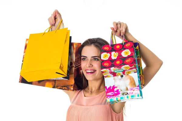 Fröhliches junges Mädchen, das vor großen bunten Päckchen mit Geschenken aufwächst- — Stockfoto