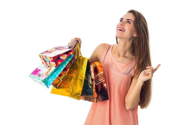 Feliz chica mira hacia arriba y la celebración de un colorido bolsas de compras aisladas sobre fondo blanco — Foto de Stock