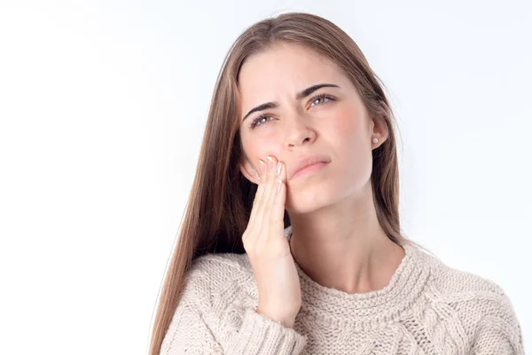 Menina sente dor de dente olha para cima e mantém sua mão para o rosto isolado no fundo branco — Fotografia de Stock