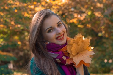 Tutar bir Fularlı güzel gülümseyen kız portresi yakın çekim yaprak