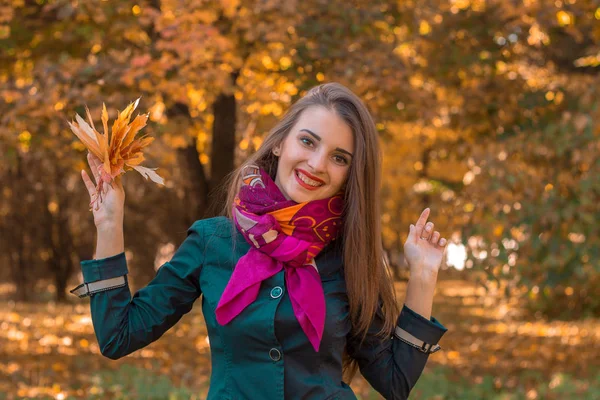 Munter tjej står i parken av leenden och lyfter upp sina händer — Stockfoto