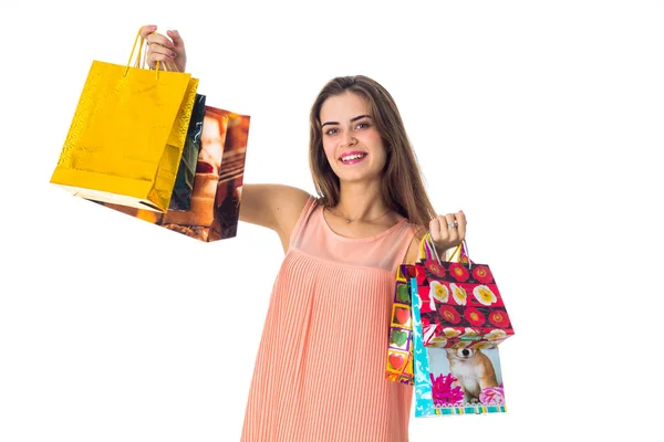 Fiatal gyönyörű lány mosolyog, és növeli a nagy színes csomagok elszigetelt fehér background — Stock Fotó