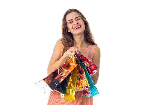 Spaß hübsches Mädchen schließt die Augen hält Pakete aus Geschäften isoliert auf weißem Hintergrund — Stockfoto