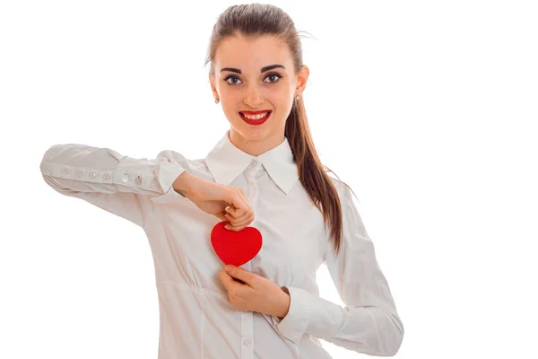 Cute brunette dziewczyna w czarnej sukni z ładny makijaż Świętuj Walentynki z czerwonym sercem w jej ręce na białym tle — Zdjęcie stockowe