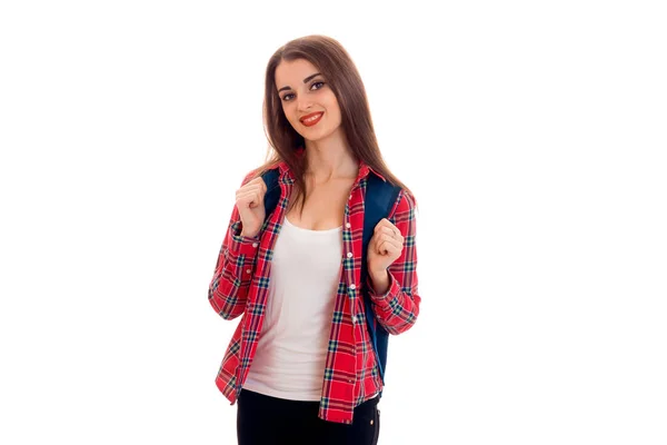 Ganska snygg smart student tjej med ryggsäck på hennes axlar poserar och leende på kamera isolerad på vit bakgrund — Stockfoto