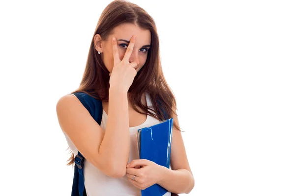 Alegre chica estudiante inteligente en ropa deportiva marrón con mochila en los hombros y carpeta para cuadernos en las manos sonriendo y mirando a la cámara aislada sobre fondo blanco — Foto de Stock