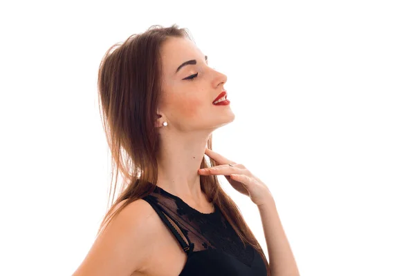 Una joven con un vestido negro se para de lado cerrando los ojos aislados sobre fondo blanco — Foto de Stock