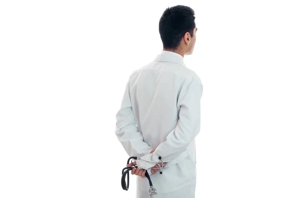 Доктор в белом платье стоит оглядываясь назад и держа стетоскоп изолирован на белом фоне — стоковое фото