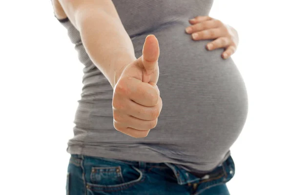 The midsection of a young pregnant woman who raised her hand forward and shows a close-up of a class is isolated on a white background — Stock Photo, Image