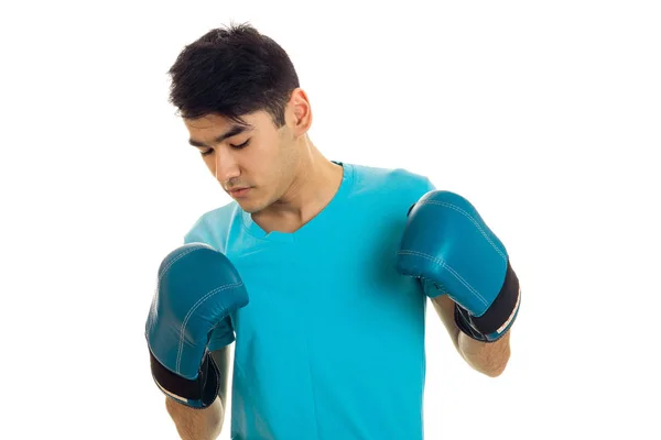 Young guy standing in boxing gloves and looking down isolated on white background — Stock Photo, Image