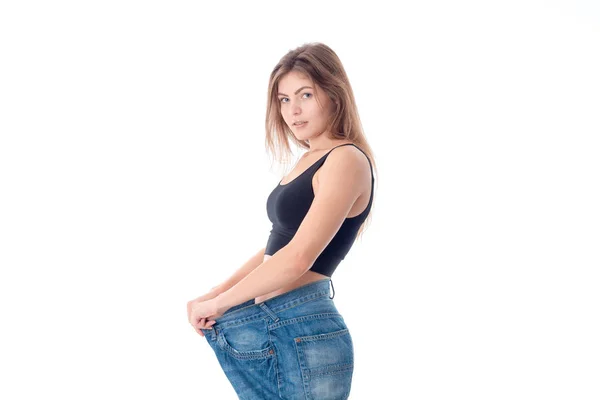 Slim ragazza si trova lateralmente in pantaloni larghi isolati su sfondo bianco — Foto Stock