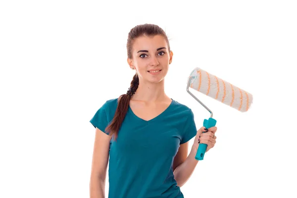 A young girl stands smiling and holding a roller for painting isolated on white background Royalty Free Stock Images