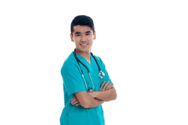 neşeli esmer delikanlı doktor mavi beyaz arka plan üzerinde izole kamera üzerinde gülümseyen onun omuzlarında stetoskop ile üniforma