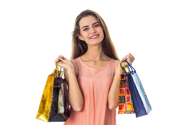 Chica joven sonriendo y sosteniendo coloridas bolsas de compras aisladas sobre fondo blanco — Foto de Stock