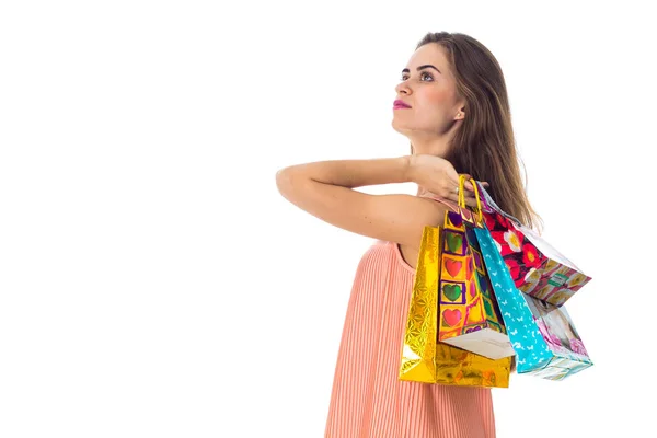 The girl stands sideways on the shoulder and raised beautiful bags isolated  white background — Stock Photo, Image