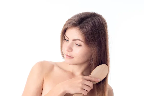 A menina olha para baixo e pentear o cabelo isolado no fundo branco — Fotografia de Stock