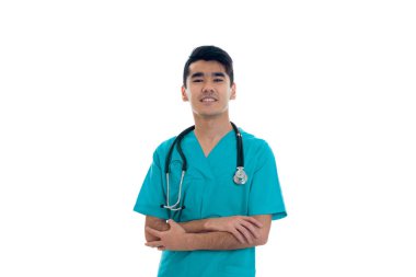 mavi beyaz arka plan üzerinde izole kamera üzerinde gülümseyen onun omuzlarında stetoskop ile Tekdüzen mutlu esmer delikanlı doktor