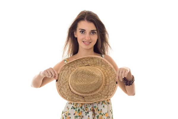 花柄のサラファン、白い背景で隔離のカメラで笑顔の広いつばの麦わら帽子でかなりブルネットの少女 — ストック写真
