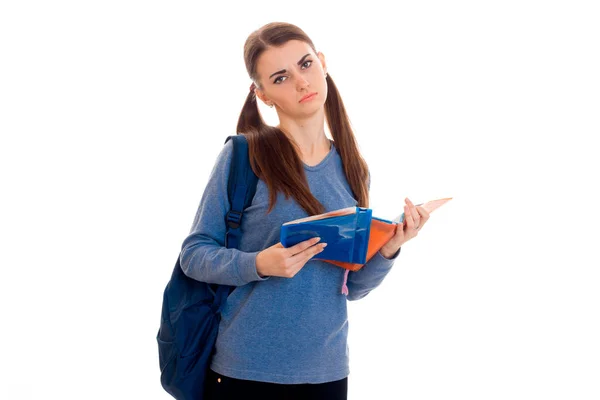 En tonårsflicka med giant håller på axeln ryggsäck och en mapp i händerna — Stockfoto