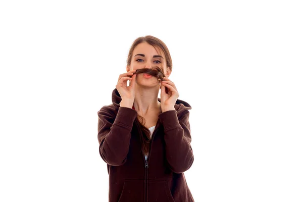 Young funny girl in brown jacket keeps hands hair near the mouth — Stock Photo, Image