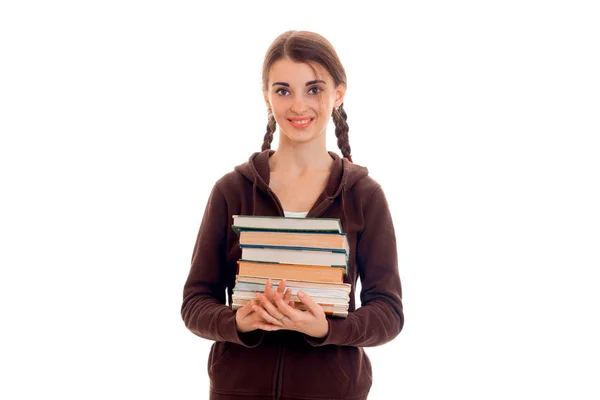 Lächelndes Teenie-Mädchen mit Zöpfen smortit rechts und hält viele Bücher — Stockfoto