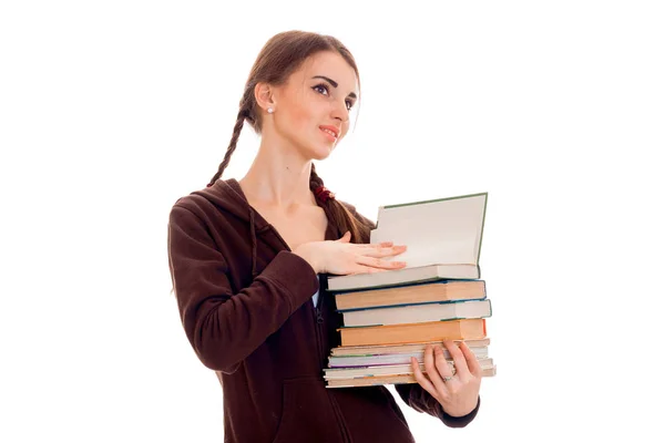 Mädchen mit Zöpfen steht seitlich und schaut weg und hält Bücher isoliert auf weißem Hintergrund — Stockfoto