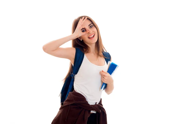 Ein fröhliches junges Mädchen im T-Shirt und mit einem Rucksack auf dem Schulterauge schließt die Hand — Stockfoto