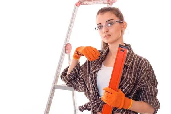 Молодая красивая женщина с темными волосами в унифорле делает ремонт с инструментами в руках изолированы на белом фоне — стоковое фото