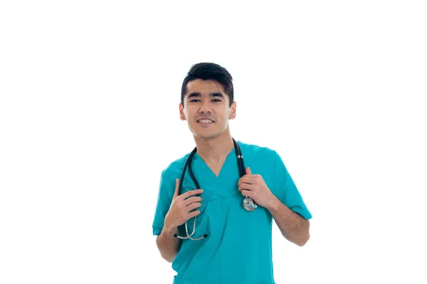 ब्लू वर्दी में युवा सुंदर डॉक्टर अपनी गर्दन पर स्टेथोस्कोप के साथ सफेद पृष्ठभूमि पर अलग — स्टॉक फ़ोटो, इमेज