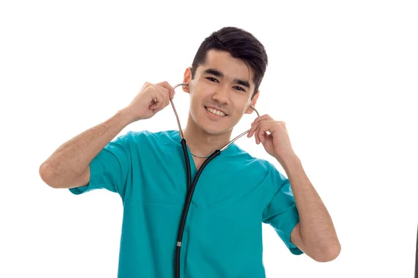 Junger, fröhlicher Arzt in blauer Uniform mit Stethoskop am Hals isoliert auf weißem Hintergrund — Stockfoto