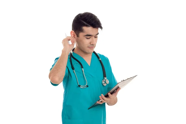 Médico adulto joven en uniforme azul con estetoscopio en el cuello aislado sobre fondo blanco —  Fotos de Stock