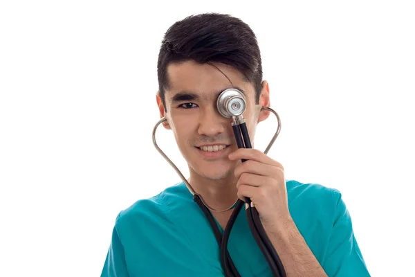 Молодой счастливый доктор в синей форме со стетоскопом на шее изолирован на белом фоне — стоковое фото