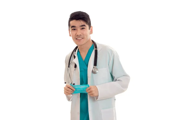 Joven médico guapo en uniforme azul con estetoscopio en el cuello aislado sobre fondo blanco —  Fotos de Stock