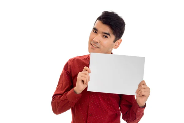 Πορτρέτο του μοντέρνα νεαρός στο κόκκινο t-shirt με άδειο πλακάτ στα χέρια του απομονώνονται σε λευκό φόντο — Φωτογραφία Αρχείου